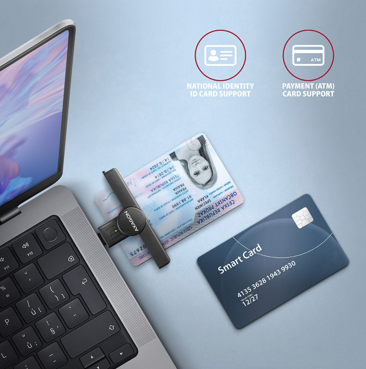 Laptop with a card reader, ID card, and ATM card on a light blue background